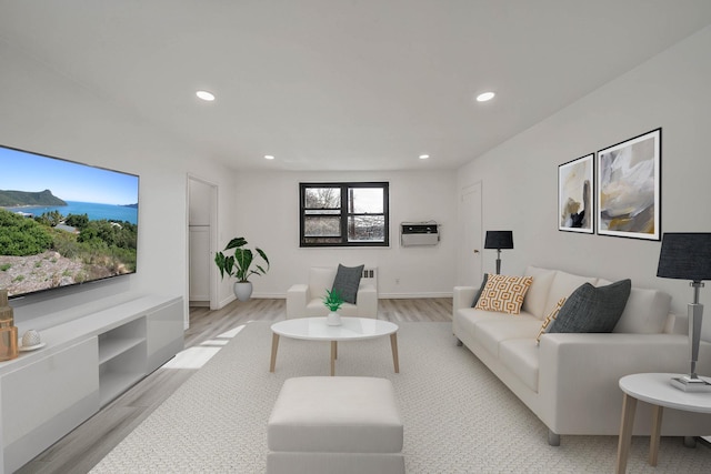 living room with light hardwood / wood-style flooring and a wall unit AC