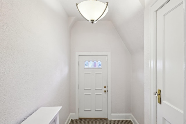 entrance foyer featuring lofted ceiling and baseboards