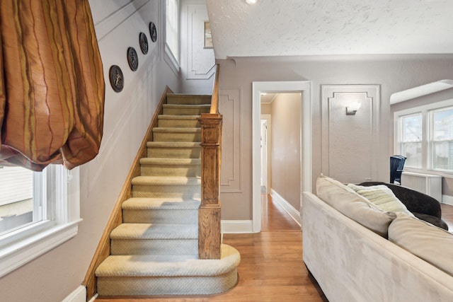 staircase featuring baseboards and wood finished floors