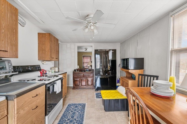 kitchen featuring a toaster, a ceiling fan, dark countertops, brown cabinets, and black appliances