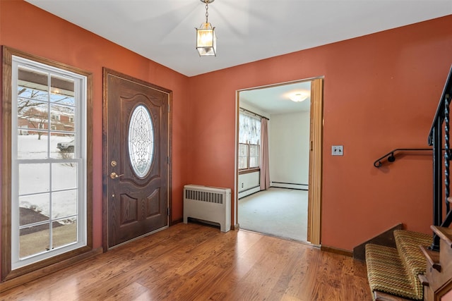 entrance foyer featuring light wood-type flooring, a baseboard heating unit, and radiator