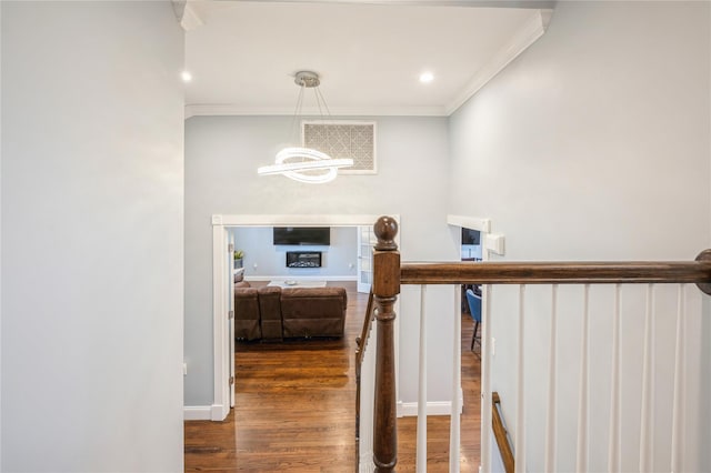 hallway featuring ornamental molding, a notable chandelier, baseboards, and wood finished floors