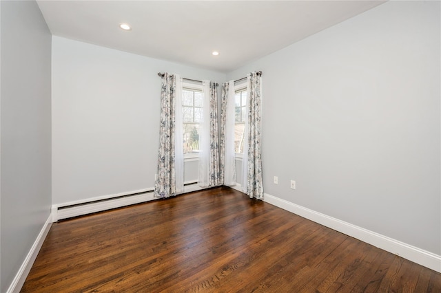 empty room with baseboards, baseboard heating, dark wood-style flooring, and recessed lighting