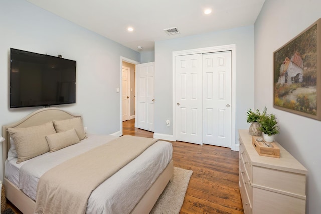 bedroom with visible vents, dark wood finished floors, a closet, and recessed lighting