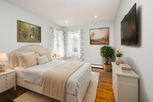 bedroom with recessed lighting, baseboard heating, and wood finished floors