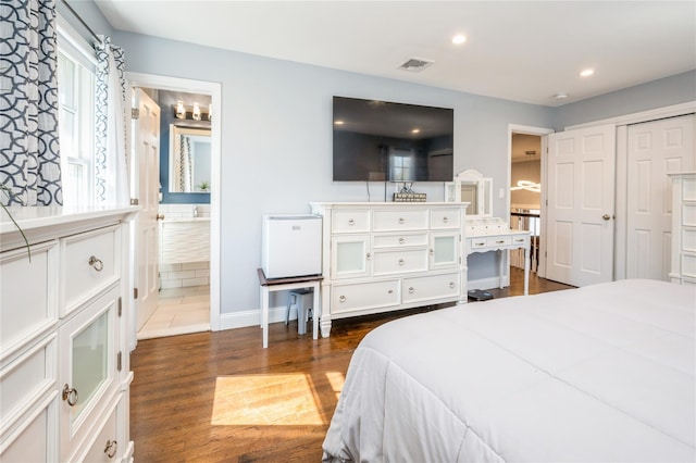 bedroom featuring recessed lighting, visible vents, baseboards, dark wood-style floors, and ensuite bath