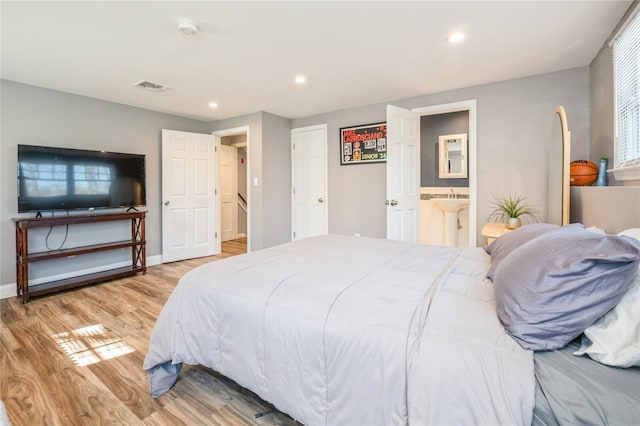 bedroom with connected bathroom, light wood-style flooring, recessed lighting, visible vents, and baseboards