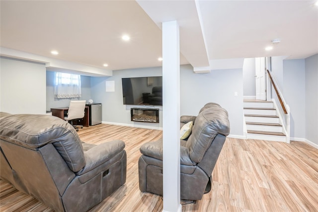 living room featuring recessed lighting, stairway, light wood-style floors, a glass covered fireplace, and baseboards