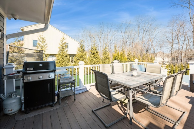 wooden deck with outdoor dining area and area for grilling