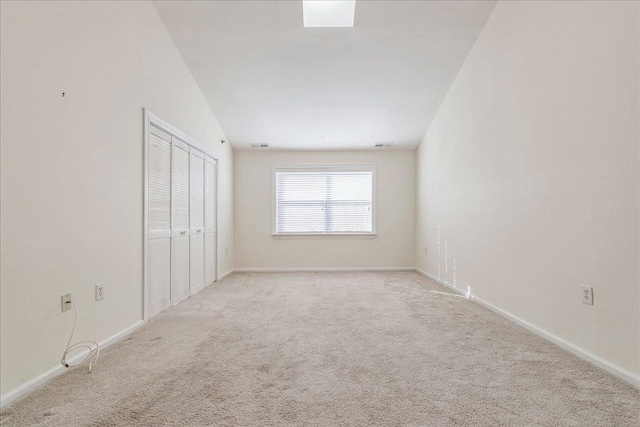 carpeted spare room featuring lofted ceiling