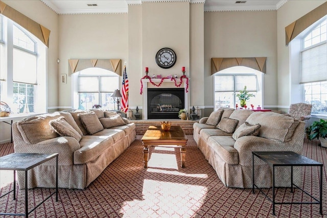 living room with ornamental molding, plenty of natural light, and a towering ceiling