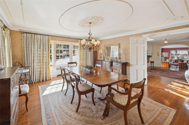 133AKA139 Hampshire Rd, Bronxville, NY 10708 - dining space featuring ornamental molding, wood finished floors, a chandelier, arched walkways, and wallpapered walls