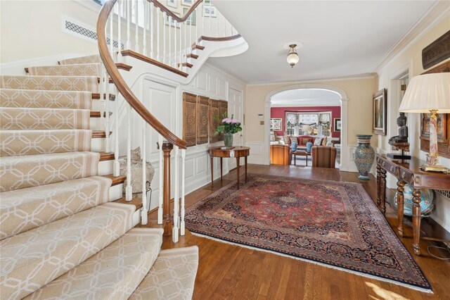 133AKA139 Hampshire Rd, Bronxville, NY 10708 - foyer entrance featuring arched walkways, wood finished floors, stairway, ornamental molding, and wainscoting