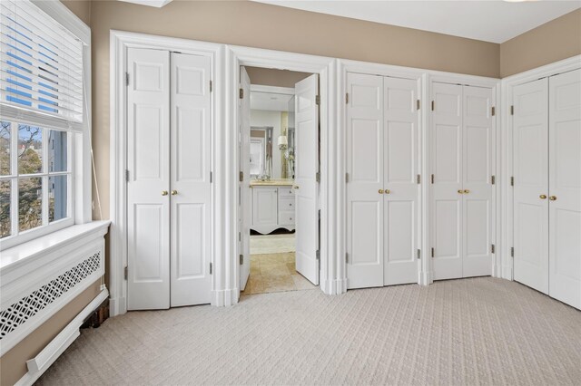 133AKA139 Hampshire Rd, Bronxville, NY 10708 - unfurnished bedroom with light colored carpet, two closets, ensuite bathroom, and radiator