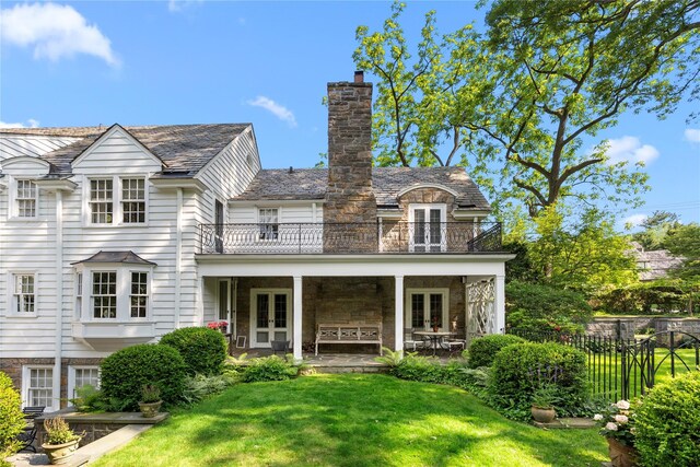 133AKA139 Hampshire Rd, Bronxville, NY 10708 - rear view of house with french doors, a balcony, a high end roof, a chimney, and stone siding