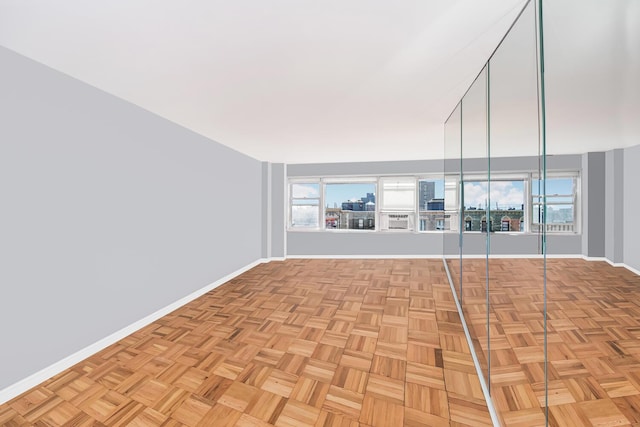 empty room with light parquet flooring and a healthy amount of sunlight