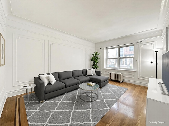 living room with ornamental molding, radiator, and hardwood / wood-style floors