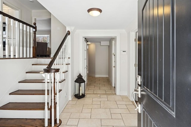 foyer with baseboards, stairway, and crown molding