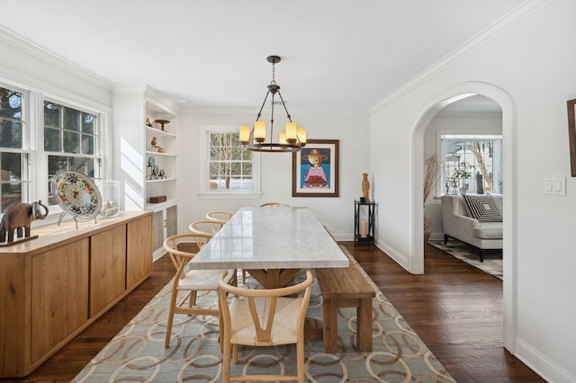 dining area featuring arched walkways, a notable chandelier, baseboards, ornamental molding, and dark wood-style floors