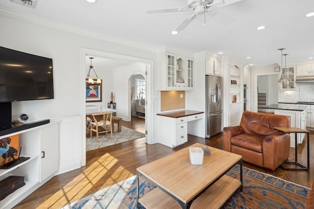 living room with arched walkways, recessed lighting, dark wood-style flooring, a ceiling fan, and ornamental molding