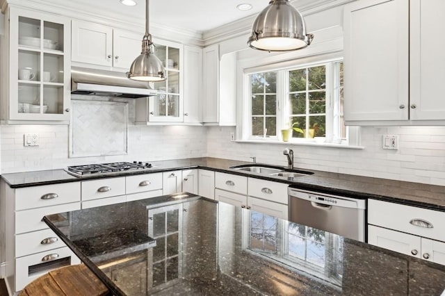 kitchen with glass insert cabinets, appliances with stainless steel finishes, decorative light fixtures, white cabinetry, and a sink