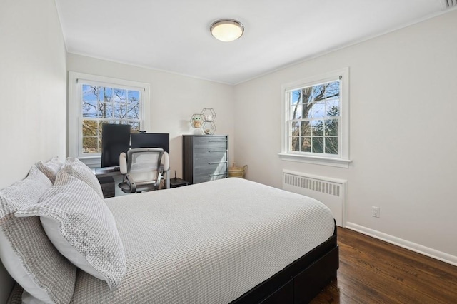 bedroom with radiator, multiple windows, baseboards, and dark wood finished floors