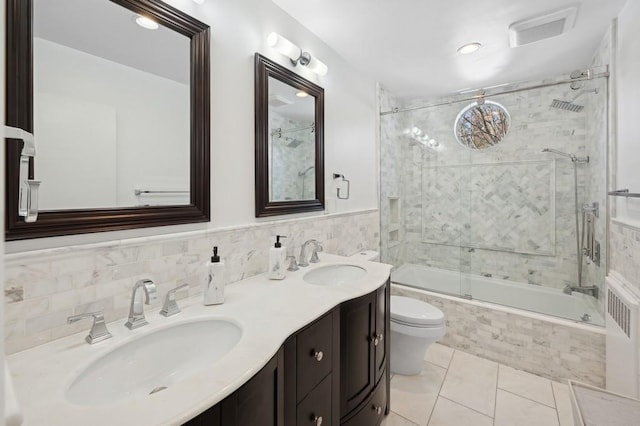 full bathroom featuring visible vents, a sink, tiled shower / bath, and toilet