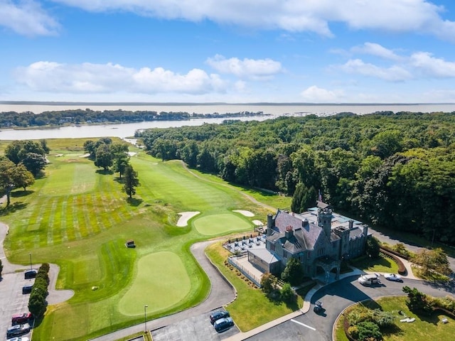 drone / aerial view featuring a forest view, golf course view, and a water view