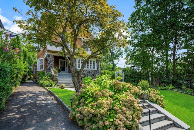 view of front of house with stone siding and a front yard