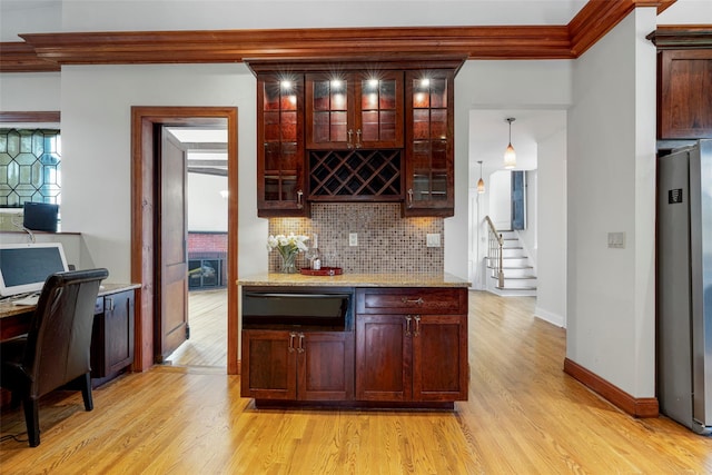 kitchen featuring a warming drawer, tasteful backsplash, light wood-style flooring, glass insert cabinets, and freestanding refrigerator