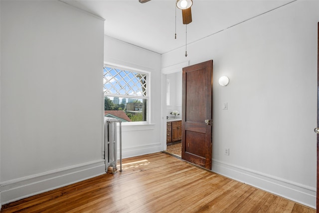 unfurnished room with a ceiling fan, baseboards, and wood finished floors