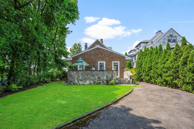 view of front facade with a chimney and a front lawn