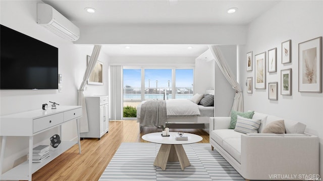 bedroom featuring light hardwood / wood-style floors and a wall mounted AC