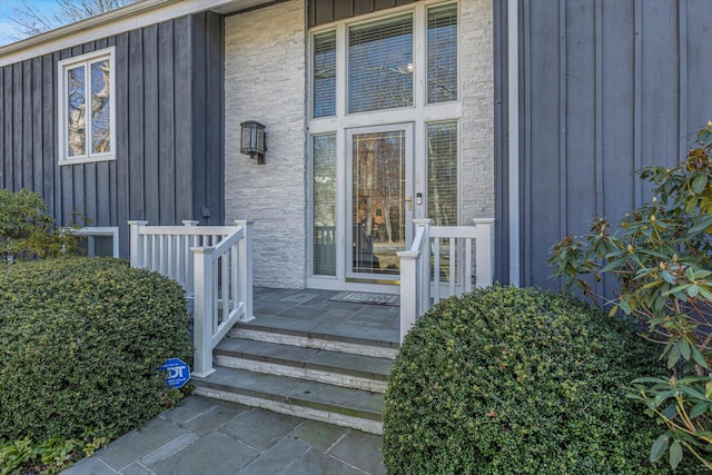 doorway to property with covered porch and board and batten siding