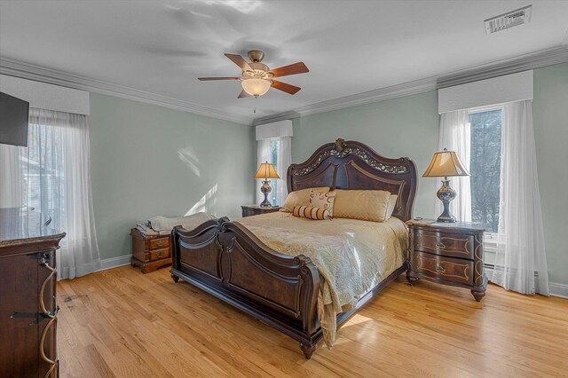 bedroom featuring light wood-style flooring, multiple windows, visible vents, and ornamental molding