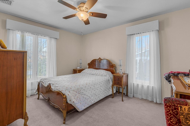 bedroom featuring visible vents, multiple windows, a ceiling fan, and carpet