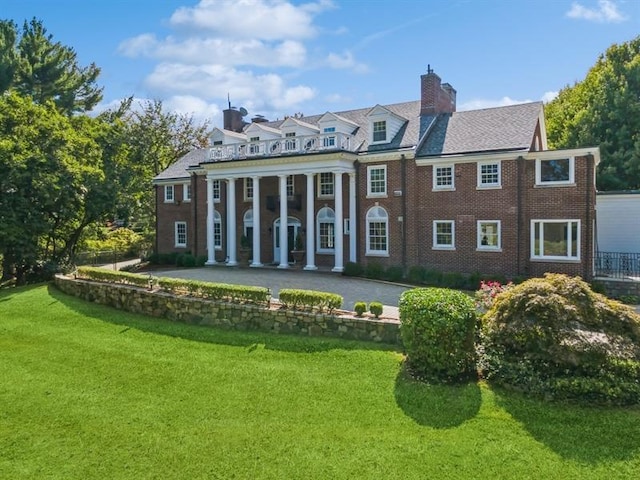 back of property featuring a lawn and a patio area