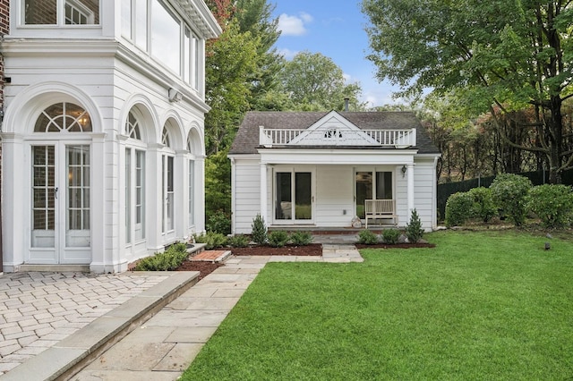 exterior space with covered porch and a front yard