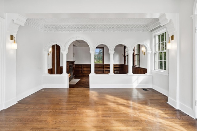 spare room with plenty of natural light, dark hardwood / wood-style floors, and ornamental molding