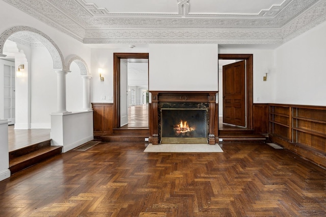 unfurnished living room with dark parquet flooring, crown molding, and a fireplace