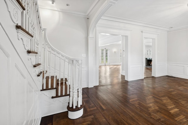 interior space featuring ornamental molding and dark parquet flooring