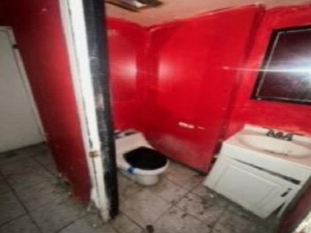 bathroom featuring toilet, vanity, and tile patterned flooring