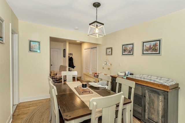 dining space featuring light wood-style flooring and baseboards