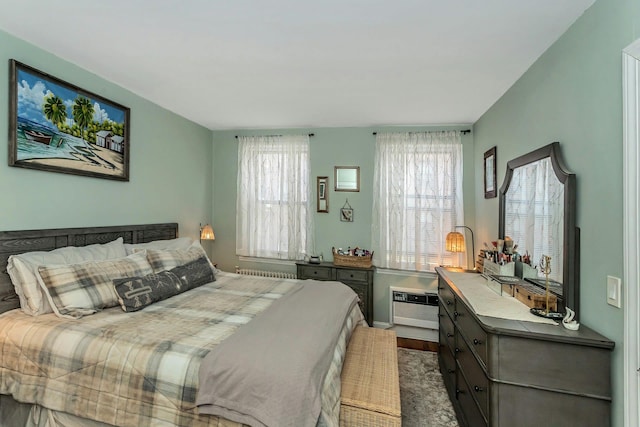 bedroom with wood finished floors and a wall mounted AC