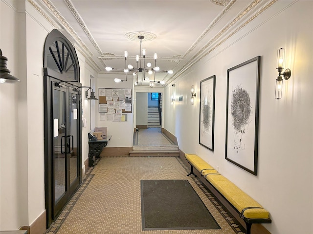 hallway featuring a notable chandelier, carpet flooring, and crown molding