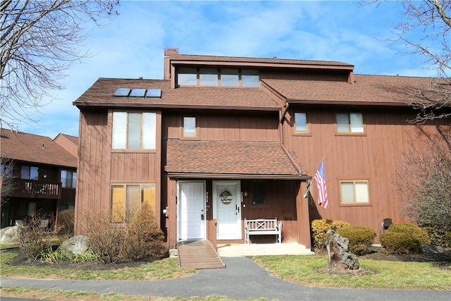 multi unit property with a chimney and roof with shingles