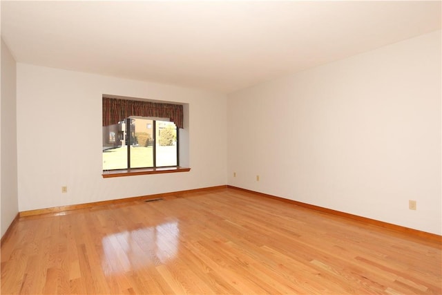 unfurnished room with light wood-style floors and baseboards