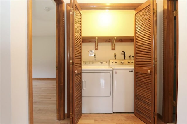 washroom featuring light wood-type flooring, laundry area, and separate washer and dryer