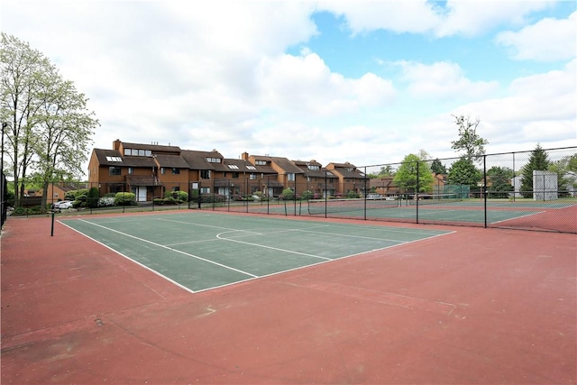 view of sport court featuring community basketball court, fence, and a residential view