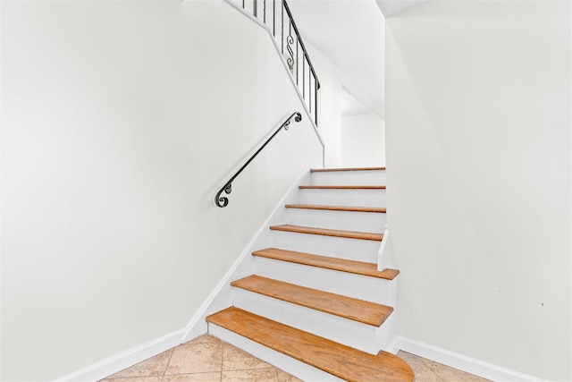 stairway featuring tile patterned flooring and baseboards